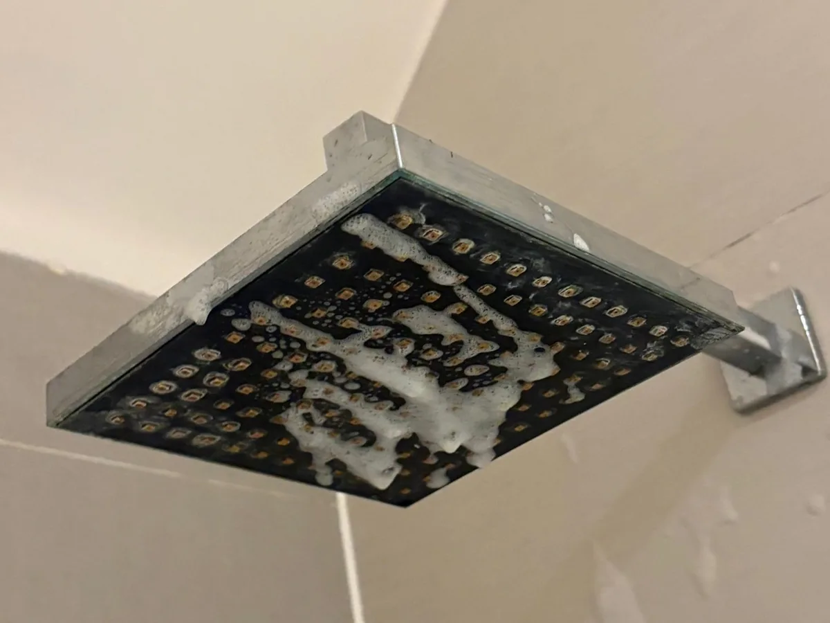 Limescaled shower head before a deep clean